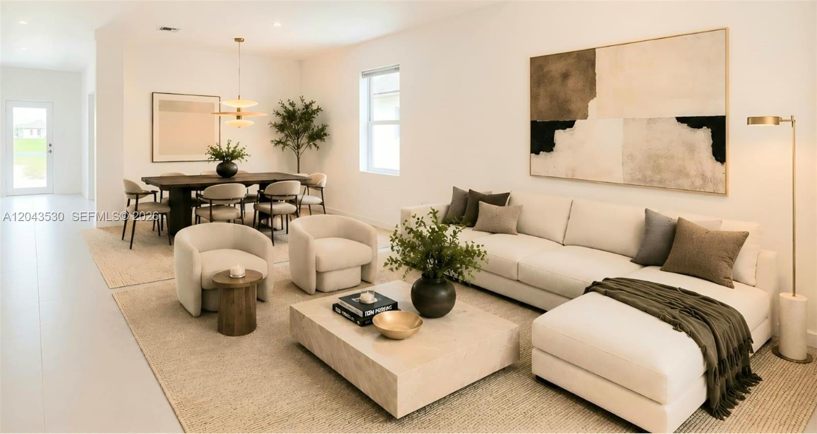 A modern open-concept living and dining area features neutral furniture, a large sectional, and artwork — 2423 SE 30th St, Homestead FL 33035, HOMESTEAD, FL