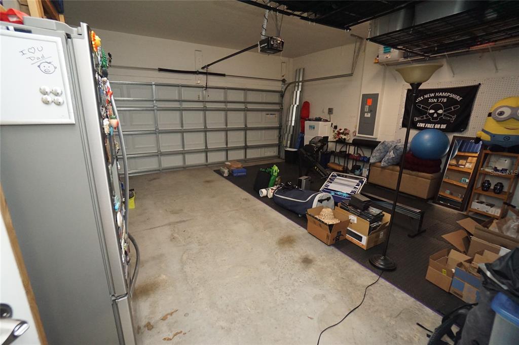 A garage with a concrete floor, a white sectional door, and various stored items — 6303 S MACDILL AVENUE, TAMPA, FL