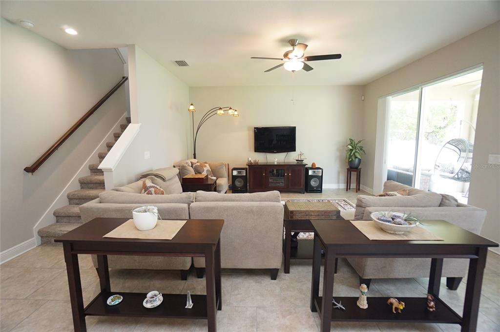 A living room features a sectional sofa, a television console, and stairs to the left — 6303 S MACDILL AVENUE, TAMPA, FL