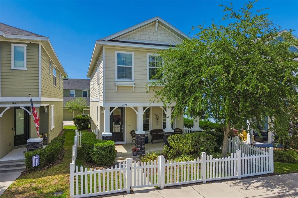 A two-story yellow house with a front porch and white picket fence — 3473 BUMELIA LANE, NEW PORT RICHEY, FL