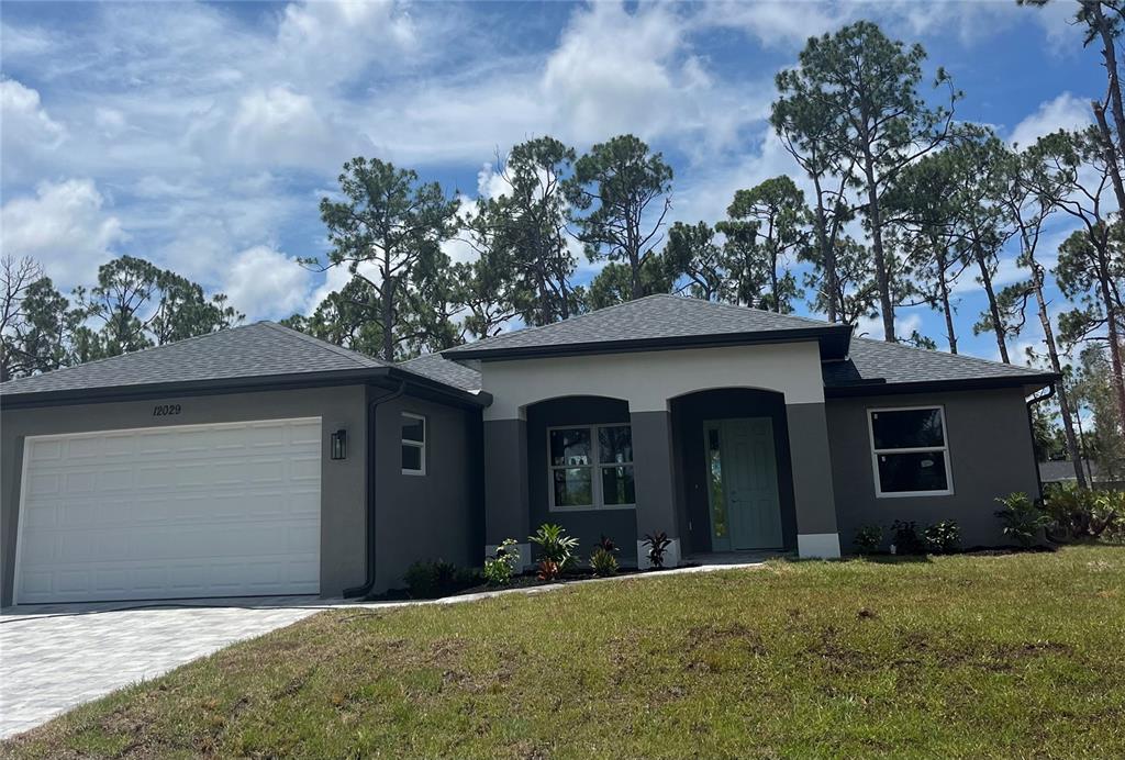 A single-story house with a gray exterior, white garage door, and a covered front entryway — 7197 TREADWAY ROAD, PORT CHARLOTTE, FL