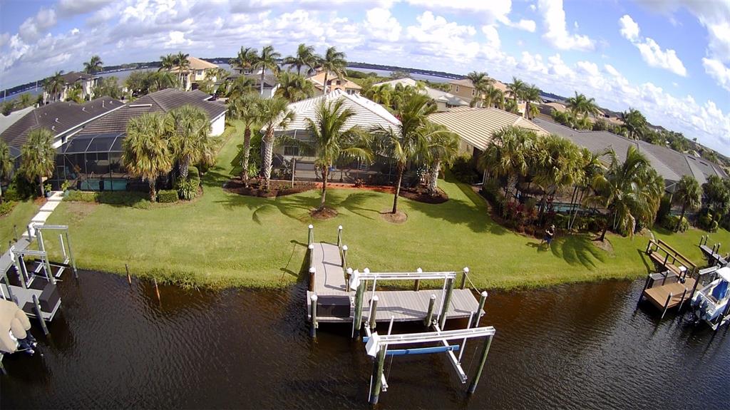 An aerial view of a waterfront backyard with a private dock and boat lift — 5117 TIDEWATER PRESERVE BOULEVARD, BRADENTON, FL