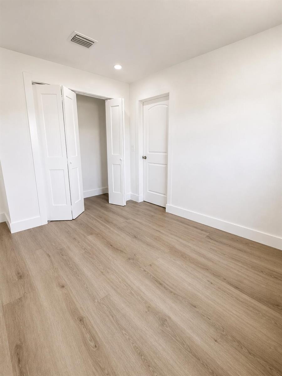An empty room with white walls, light wood-look flooring, a closet, and a closed door — 4181 Winchester Lane, FL 33406, FL