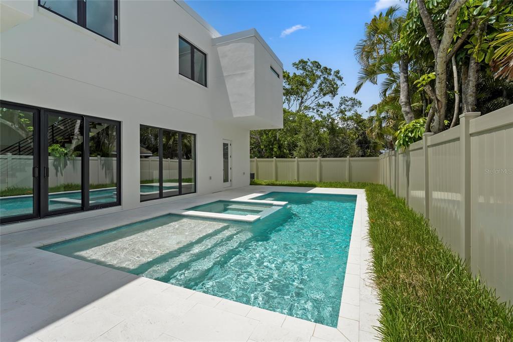 A modern white house exterior features a swimming pool with an integrated spa and patio — 2604 SYDELLE STREET, SARASOTA, FL