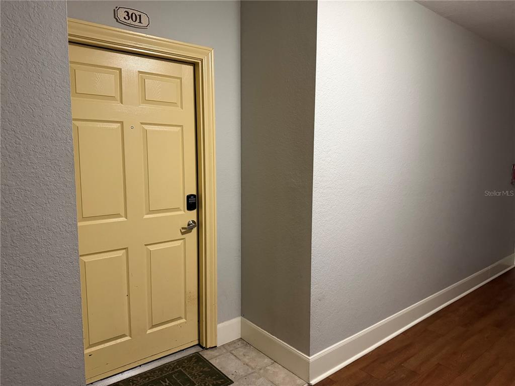 A yellow apartment door labeled 301 is set in a hallway with light-colored walls — 860 N ORANGE AVENUE UNIT 301, ORLANDO, FL