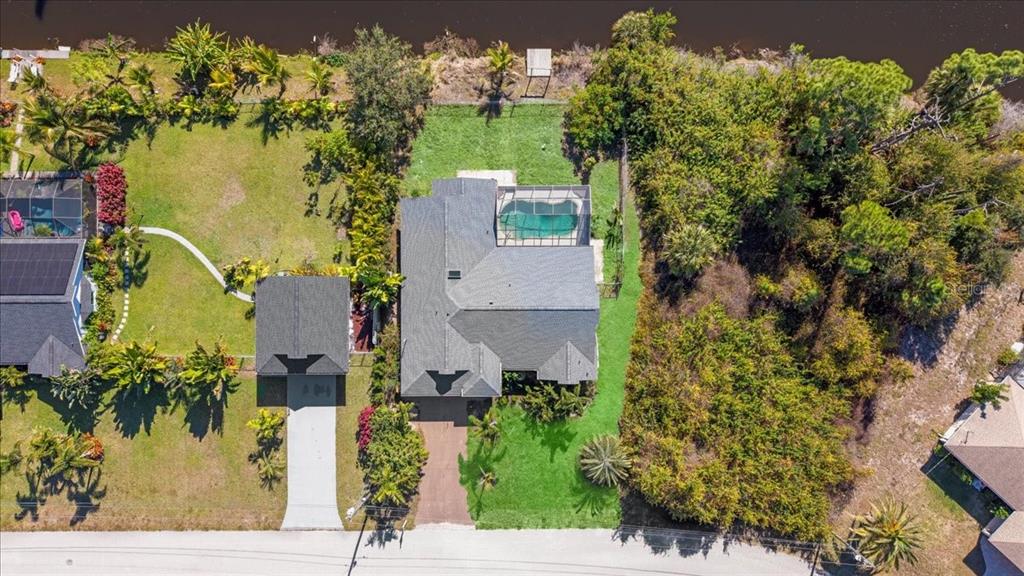 An aerial view shows a house with a pool and a detached garage on a lot — 11195 SEABREEZE AVENUE, PORT CHARLOTTE, FL