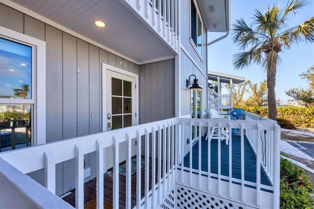 An exterior view of a gray-sided building with a white railed balcony and door 38 — 6000 BOCA GRANDE CAUSEWAY UNIT D38, BOCA GRANDE, FL