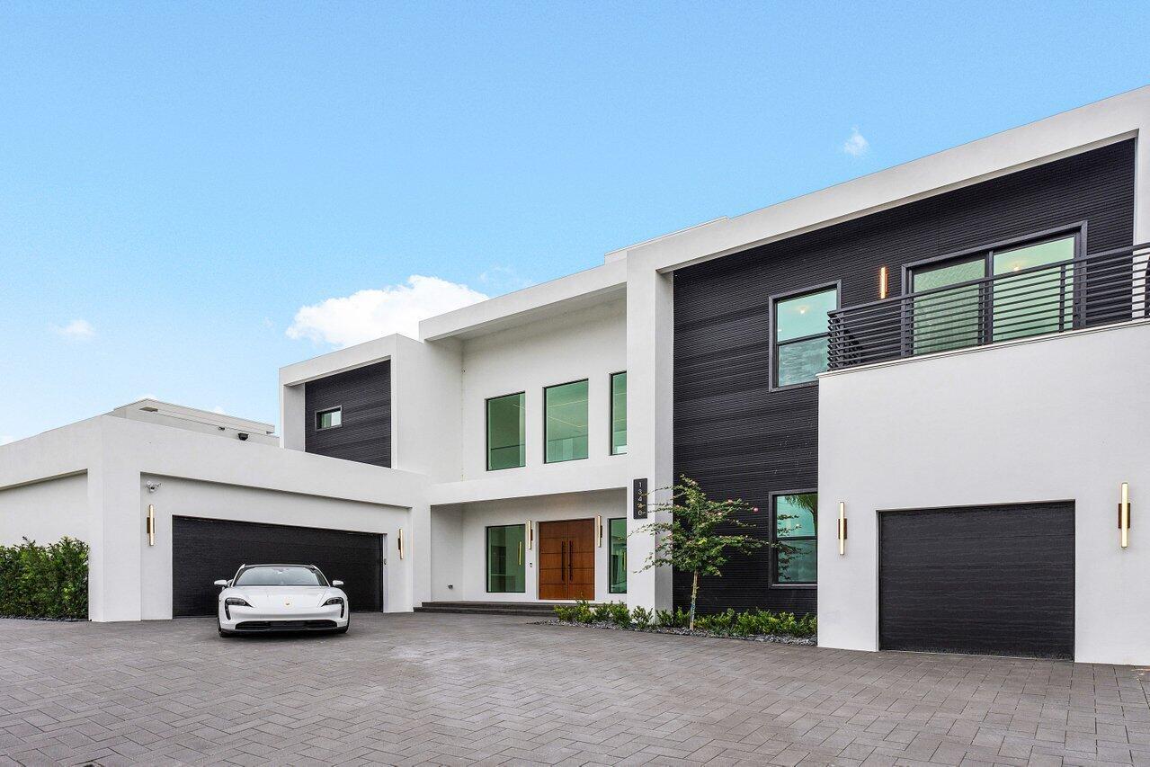 A modern two-story house with white stucco, black siding, two garages, and a paved driveway — 13440 Us Highway 1, Juno Beach FL 33408, JUNO BEACH, FL