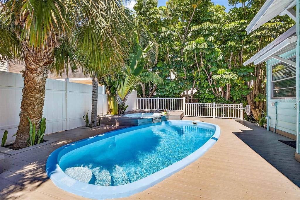 A backyard features a small swimming pool, a hot tub, and a wooden deck — 26 CAMBRIA STREET, CLEARWATER BEACH, FL