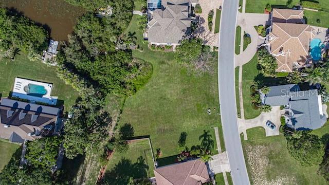 An aerial view shows a vacant residential lot situated between several houses and a lake — 0 N POINTE ALEXIS DRIVE, TARPON SPRINGS, FL