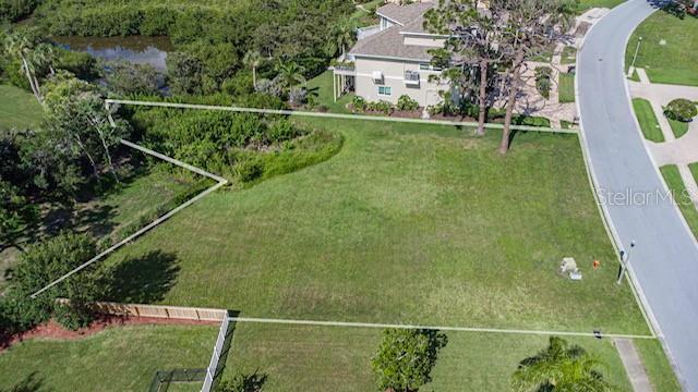 An aerial view shows a vacant, grassy residential lot outlined in white next to a road — 0 N POINTE ALEXIS DRIVE, TARPON SPRINGS, FL