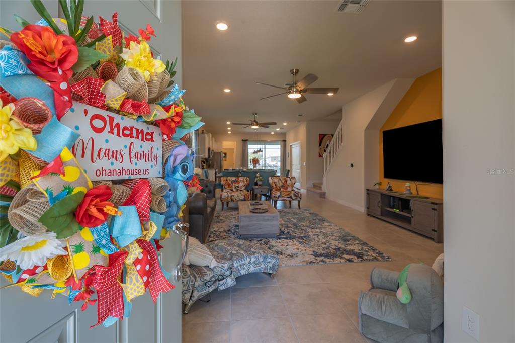 A view from a doorway into a living room featuring a large television and furniture — 3811 LANA AVENUE, DAVENPORT, FL