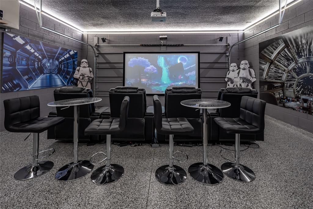 A home theater garage conversion features a projector screen, theater seating, and Star Wars decor — 3811 LANA AVENUE, DAVENPORT, FL