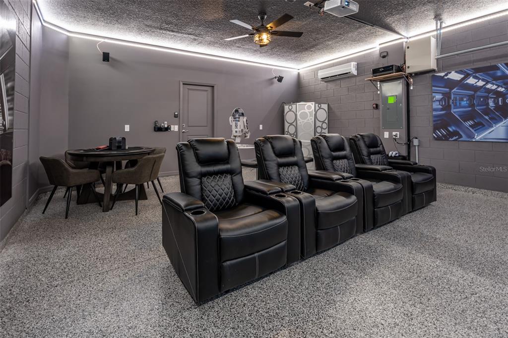 A home theater room features four black leather recliners, a game table, and LED lighting — 3811 LANA AVENUE, DAVENPORT, FL