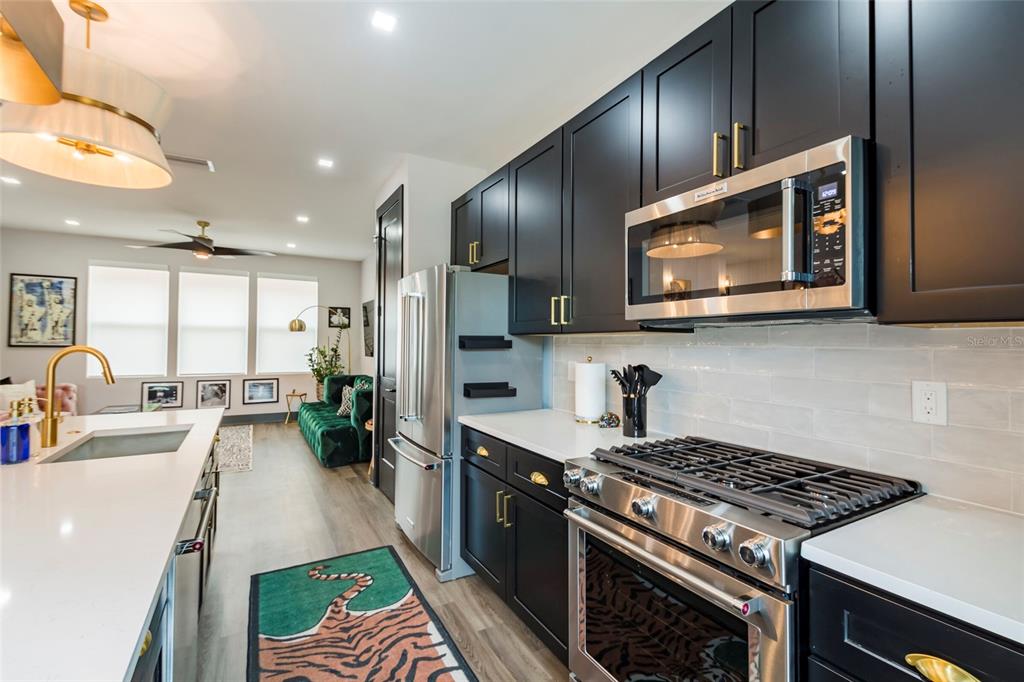 A modern kitchen features black cabinets, stainless steel appliances, and a white quartz island — 33 29TH STREET N, ST PETERSBURG, FL