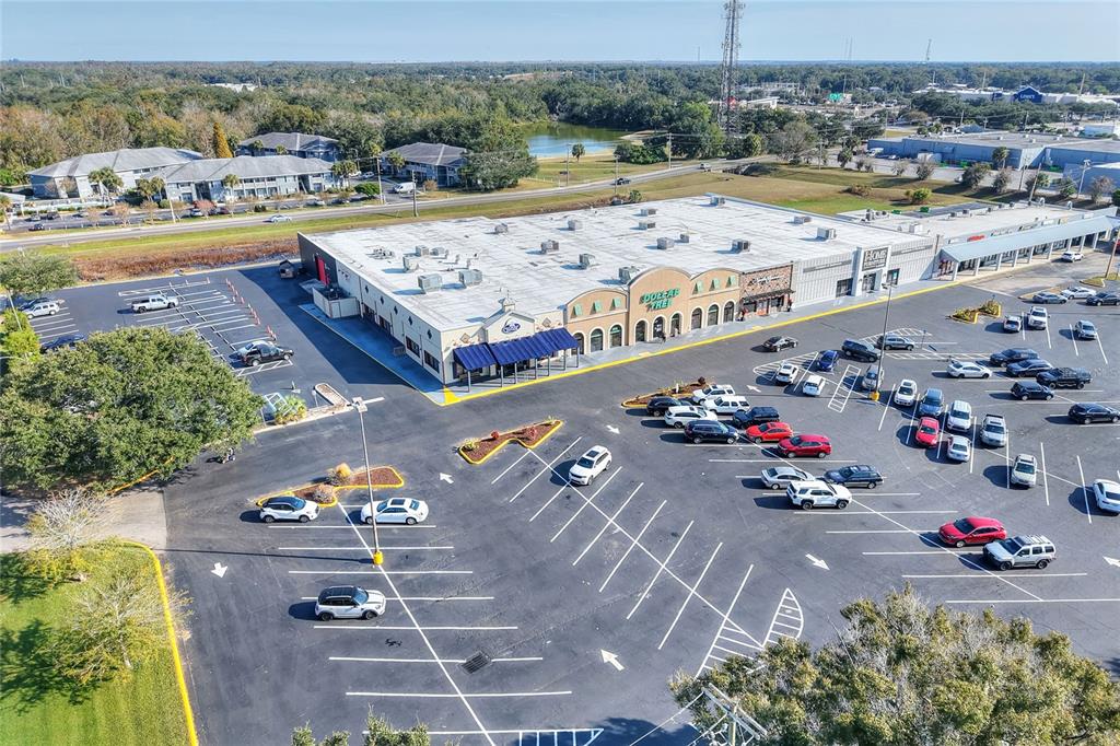 An aerial view shows a commercial strip mall with a large parking lot — 1370 N BROADWAY AVENUE, BARTOW, FL