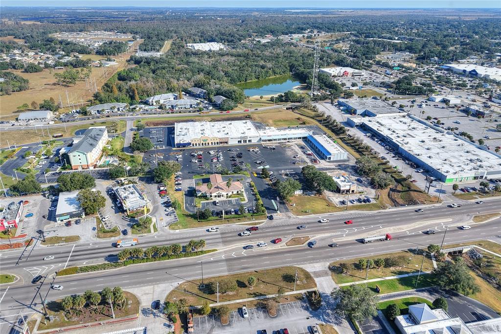 An aerial view shows a commercial shopping center with parking lots and surrounding roads — 1370 N BROADWAY AVENUE, BARTOW, FL