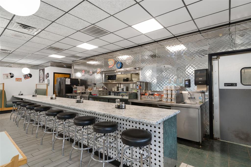 A diner interior features a long granite-topped counter with black stools and metallic wall panels — 5300 E SILVER SPRINGS BOULEVARD UNIT B, SILVER SPRINGS, FL