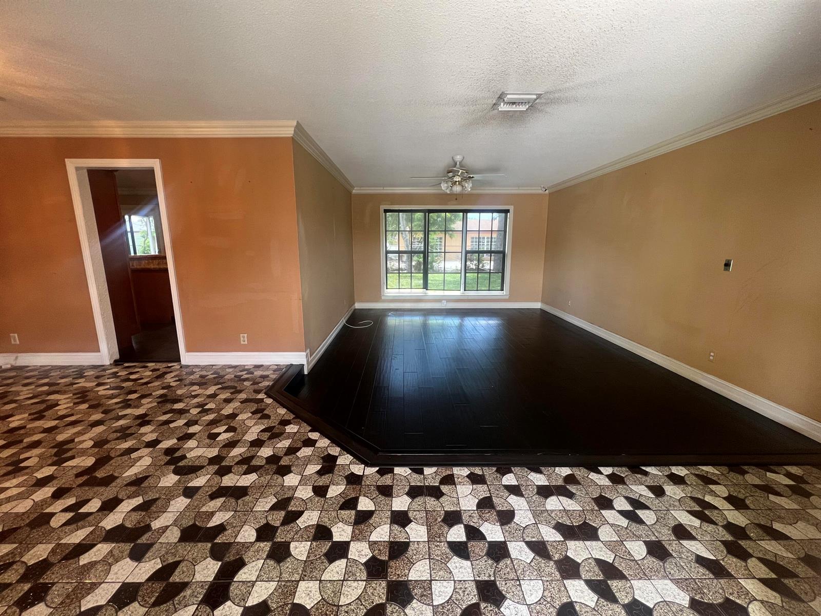A dining area with dark wood floors opens to a kitchen and a screened patio — 511 SW 63rd Terrace, Margate FL 33068, MARGATE, FL