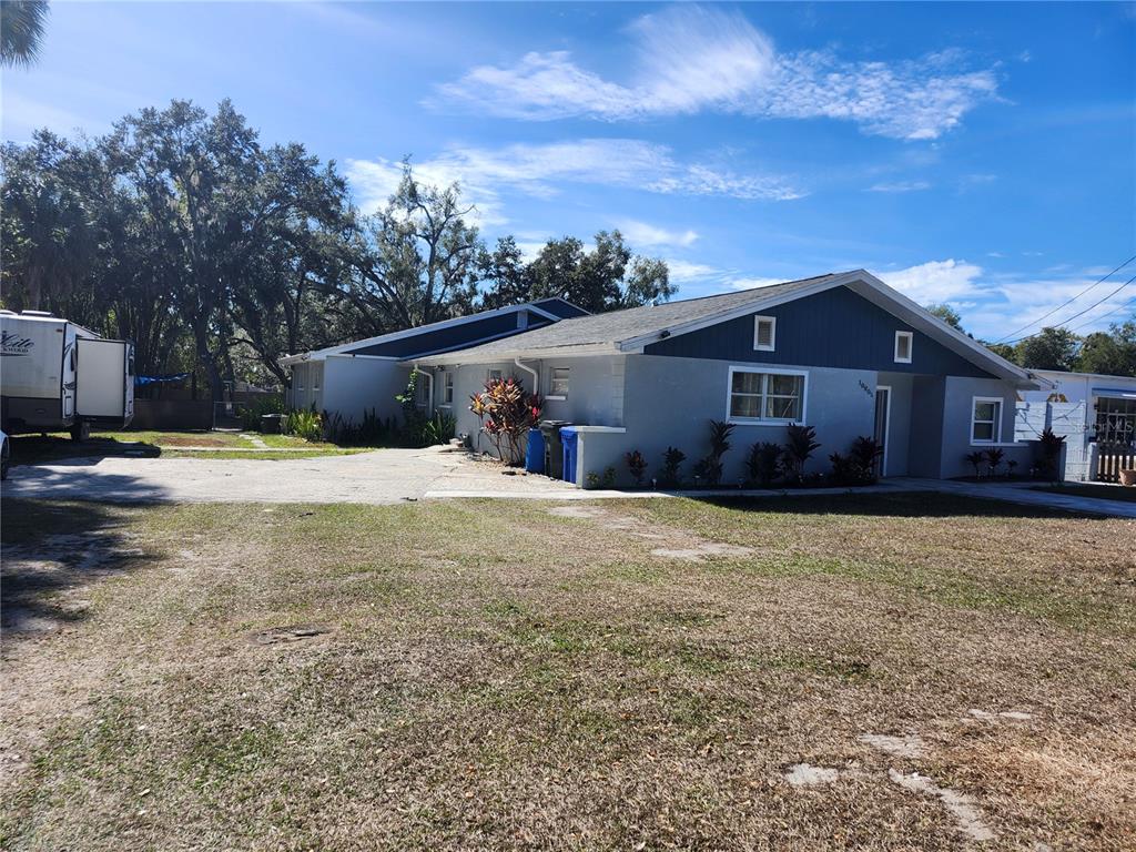 A single-story house with a gray exterior, a concrete driveway, and a parked camper trailer — 10805 DESOTO ROAD, RIVERVIEW, FL