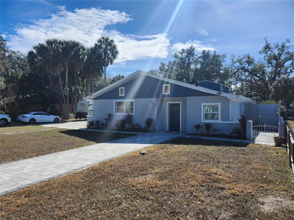 A single-story house with a gray exterior, a paved walkway, and a white fence — 10805 DESOTO ROAD, RIVERVIEW, FL