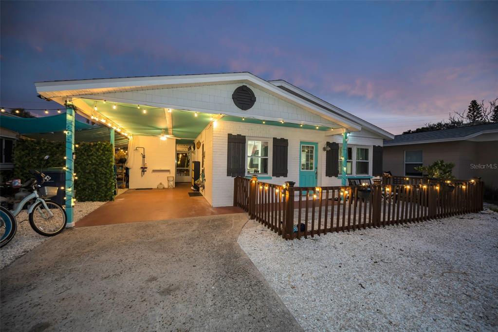 A white house with a turquoise door, a wooden deck, and a golf cart parked outside — 305 15TH AVENUE, INDIAN ROCKS BEACH, FL