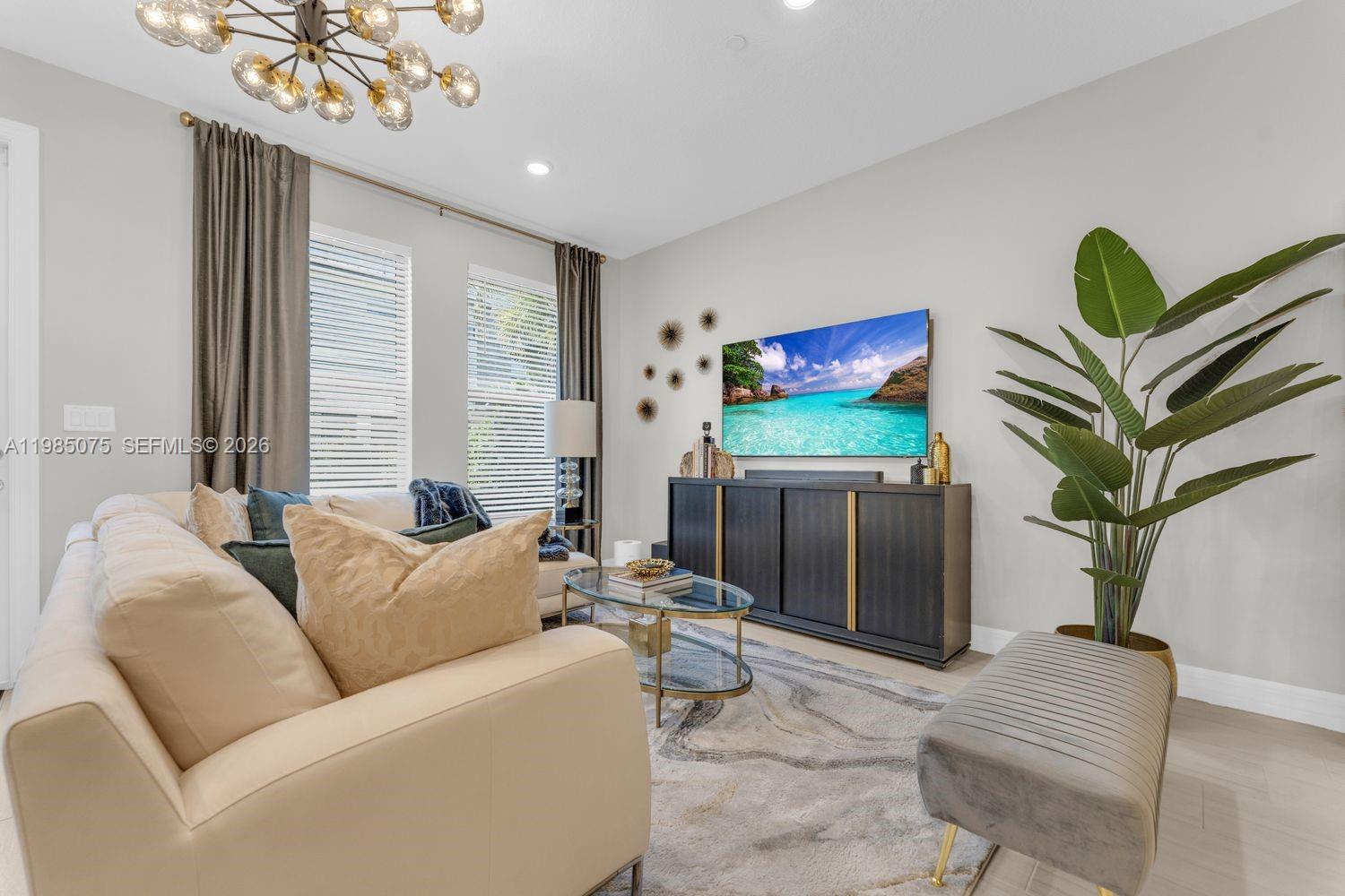 A living room features a beige sofa, a television on a dark console, and a plant — 8351 NW 7th Ct, Plantation FL 33324, PLANTATION, FL