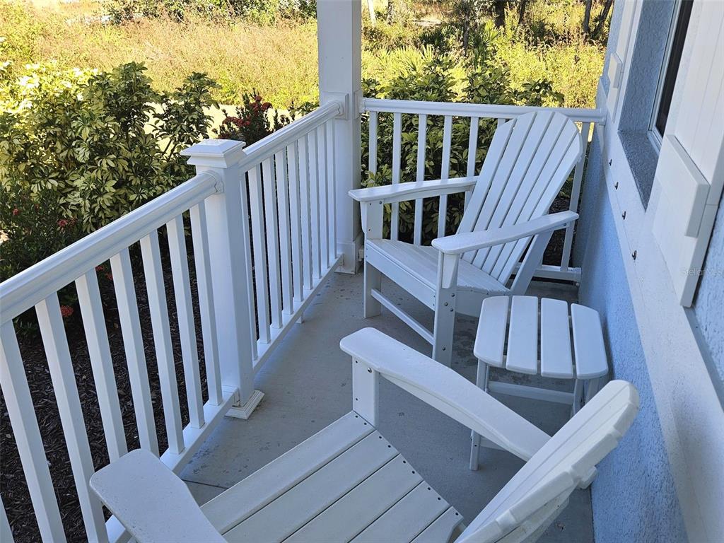 A white porch features two Adirondack chairs and a small side table — 2172 PEASLEY STREET, PORT CHARLOTTE, FL