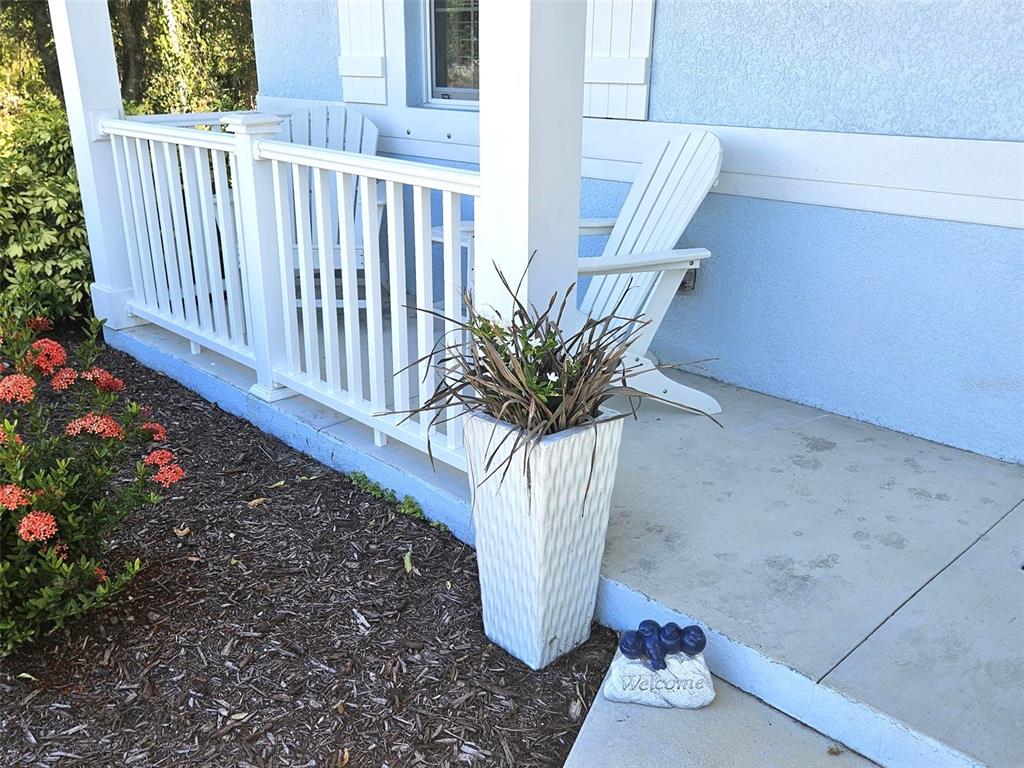 A white planter and a welcome stone sit on a porch with white railings — 2172 PEASLEY STREET, PORT CHARLOTTE, FL
