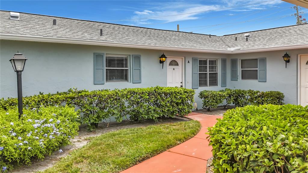 A light blue exterior wall features a white front door labeled A and a window — 2188 CORINNE COURT S UNIT A, ST PETERSBURG, FL