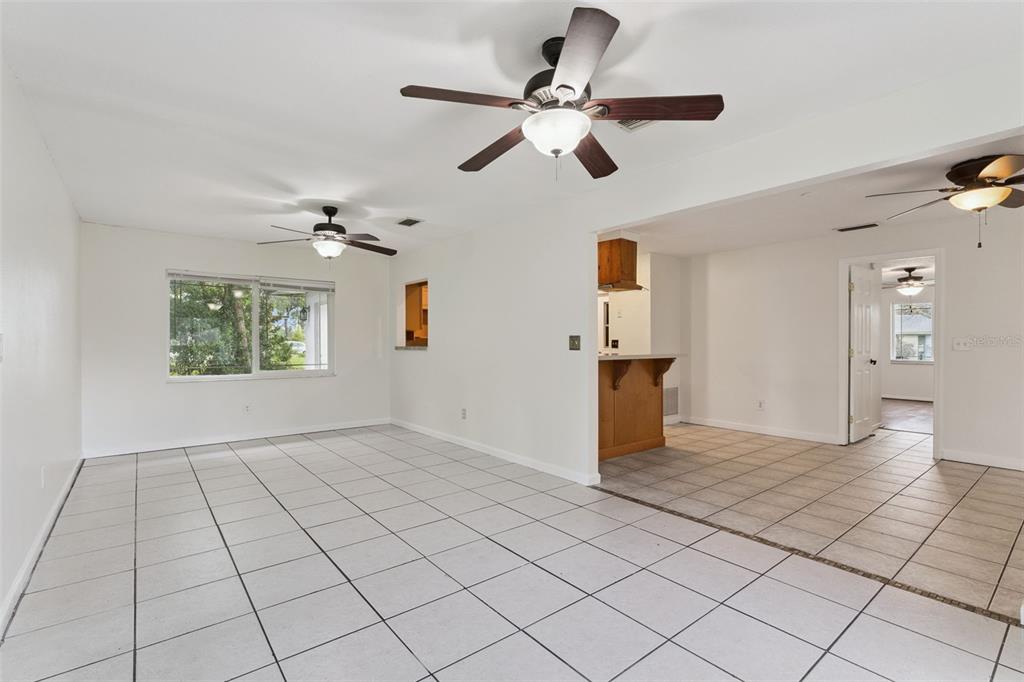 An open-concept living area features white walls, tiled floors, and three ceiling fans — 2142 KENDALL COURT, DELTONA, FL