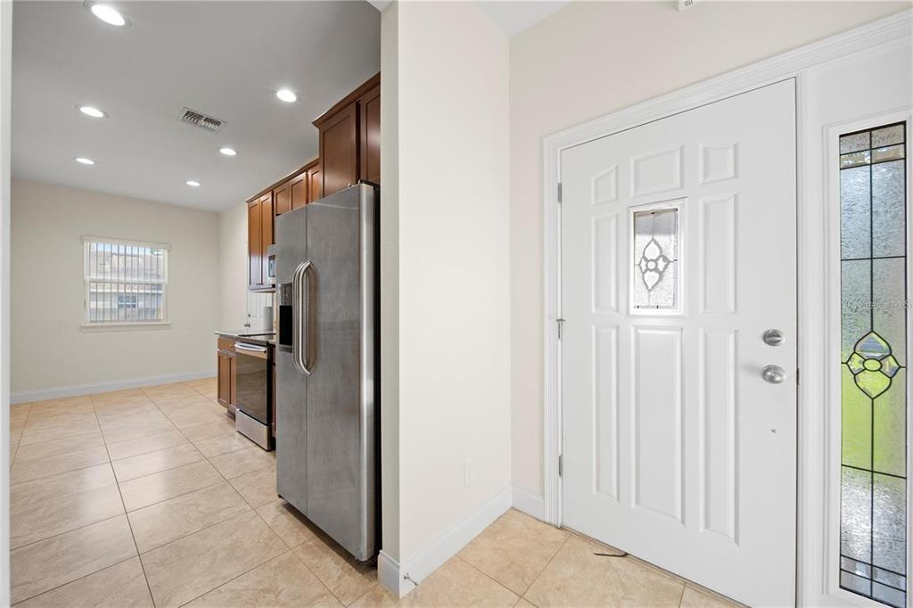 A kitchen with tile floors and stainless steel appliances is visible next to an entryway door — 14 FERGUSON DRIVE, ORLANDO, FL