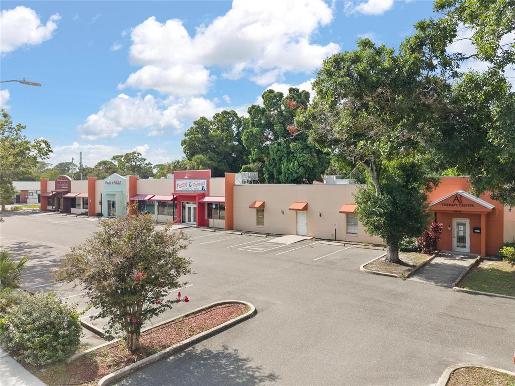 An exterior view of a single-story commercial strip mall with a parking lot in front — 6295 CENTRAL AVENUE, ST PETERSBURG, FL