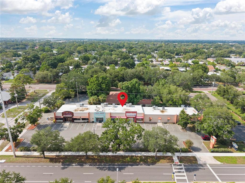 An aerial view shows a single-story commercial strip mall with a parking lot — 6295 CENTRAL AVENUE, ST PETERSBURG, FL