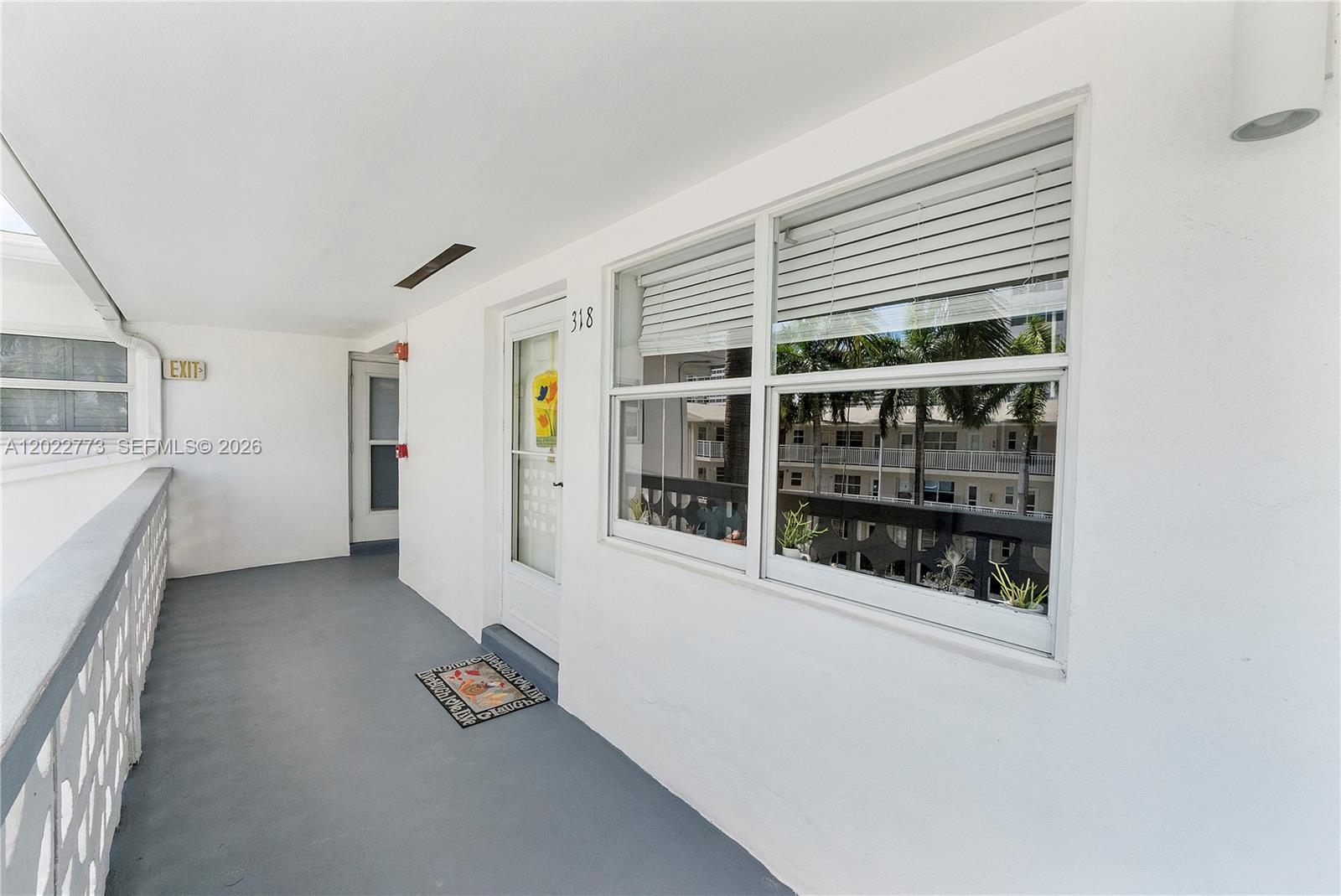 An exterior walkway leads to the front door of a unit numbered 318 — 3133 S Ocean Dr # 318, Hallandale Beach FL 33009, HALLANDALE BEACH, FL