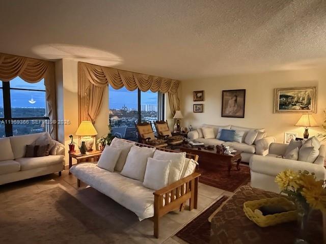A living room features light-colored sofas, a wooden coffee table, and large windows with valances — 600 Three Islands Blvd # 1004, Hallandale Beach FL 33009, HALLANDALE BEACH, FL