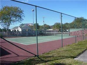 A fenced-in outdoor tennis court with a green playing surface and red surrounding area — 9110 TUDOR DRIVE UNIT L106, TAMPA, FL