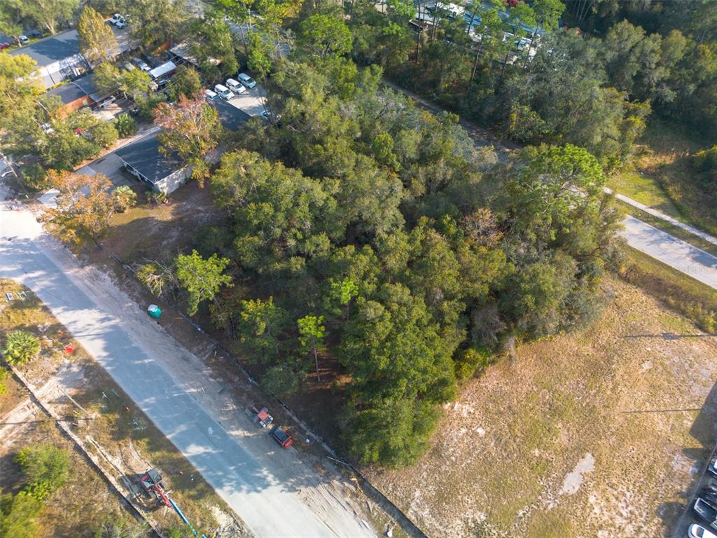 An aerial view shows a wooded, undeveloped rectangular lot situated between two paved roads — 290 S INDUSTRIAL DRIVE, ORANGE CITY, FL