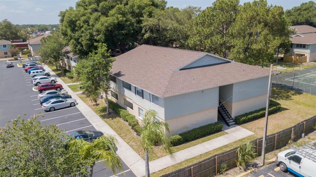 An aerial view shows a two-story apartment building with a parking lot and trees — 233 THORN TREE PLACE, BRANDON, FL
