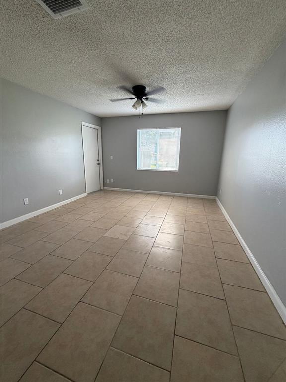 An empty room with gray walls, a ceiling fan, and light-colored tile flooring — 233 THORN TREE PLACE, BRANDON, FL