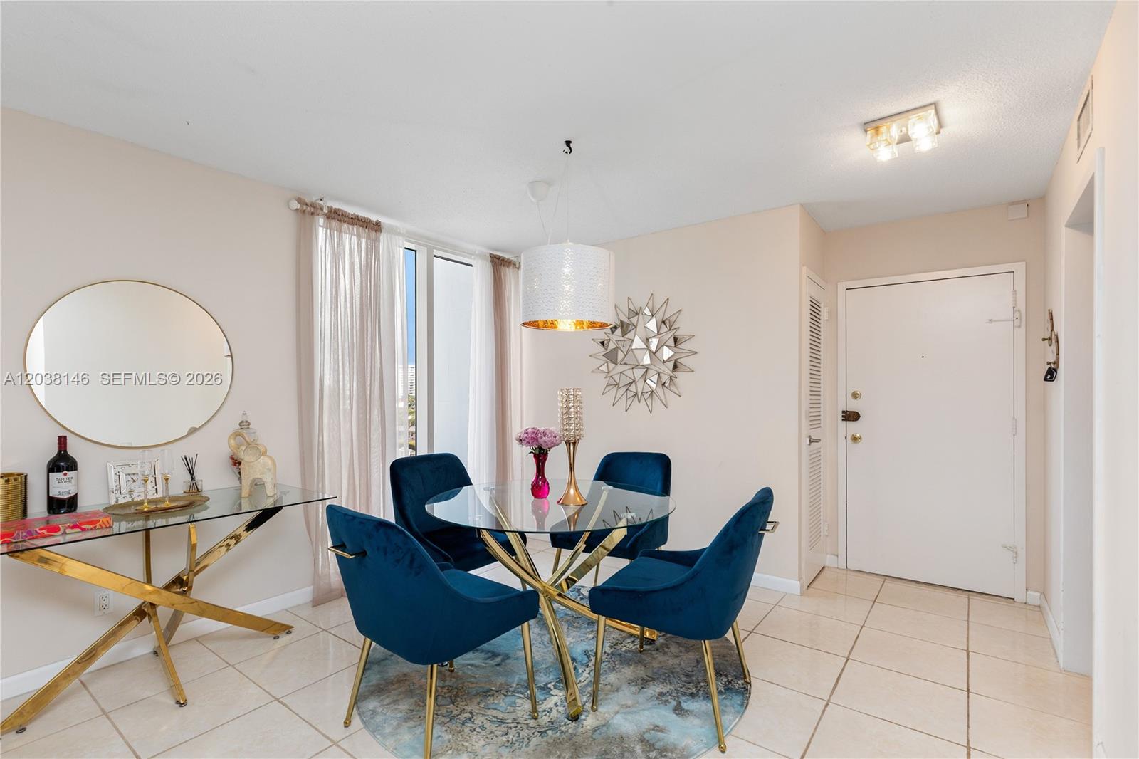 A dining area features a glass table, four blue velvet chairs, and a round mirror — 2030 S Ocean Dr # 307, Hallandale Beach FL 33009, HALLANDALE BEACH, FL