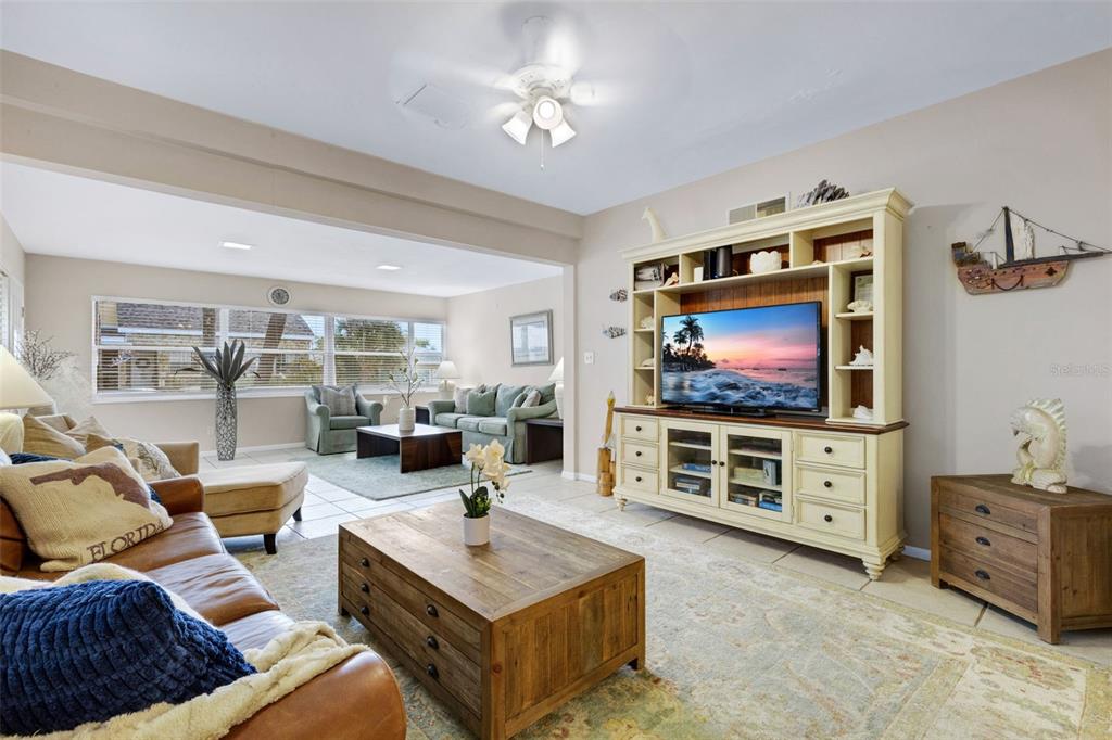 A living room features a large entertainment center, a leather sofa, and tile flooring — 18 HEILWOOD STREET, CLEARWATER, FL