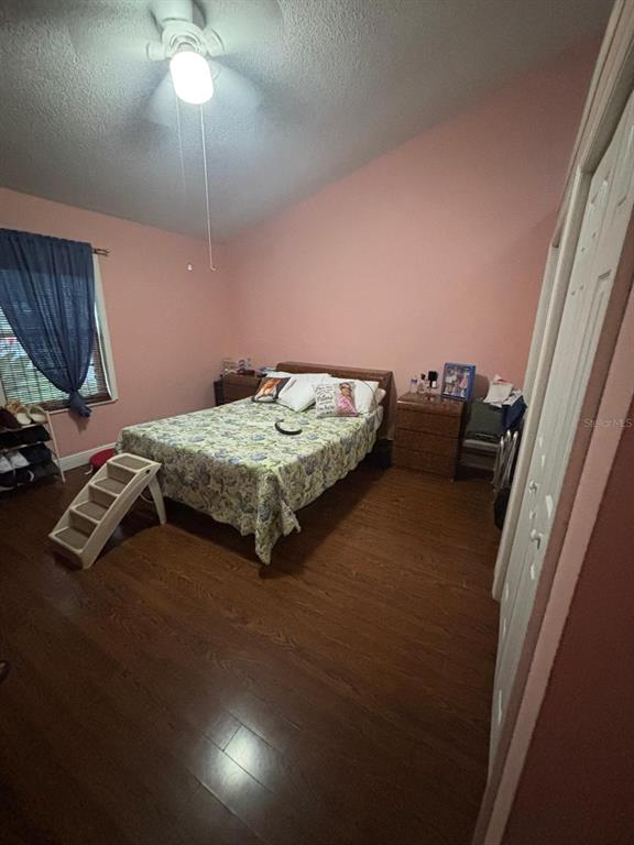 A bedroom features pink walls, wood-look flooring, a ceiling fan, and a bed with bedding — 41 WATER TRACK DRIVE, OCALA, FL