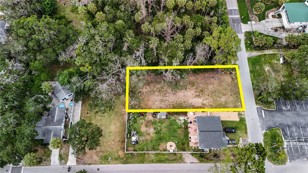 An aerial view shows a rectangular vacant lot outlined in yellow next to a house — 7751 PIER ROAD, PORT RICHEY, FL