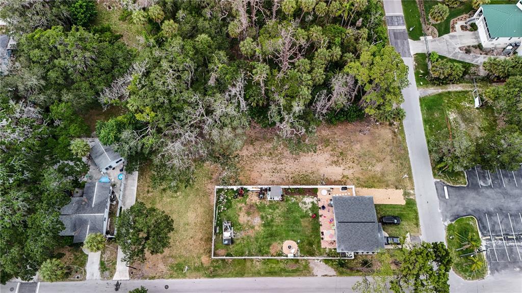 An aerial view shows a residential lot with a house, fenced yard, and surrounding trees — 7751 PIER ROAD, PORT RICHEY, FL