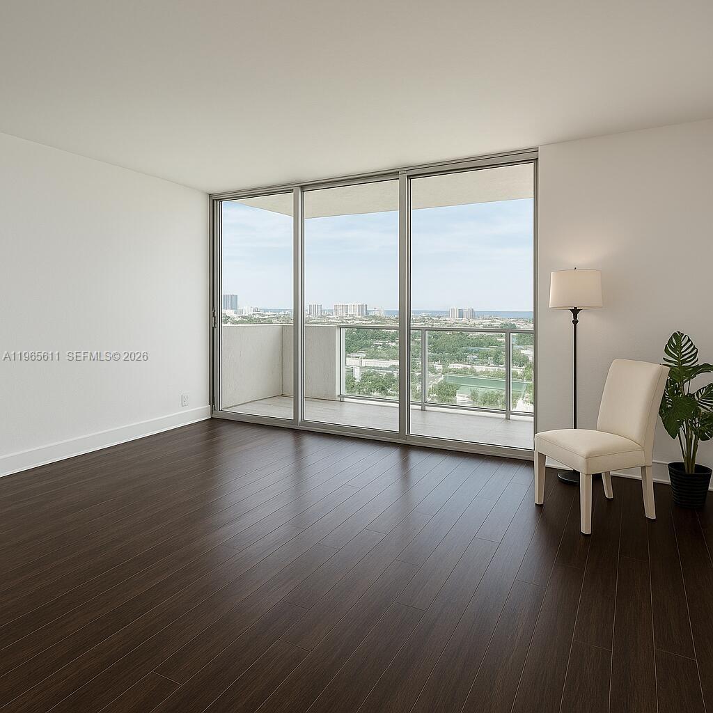 An empty room features dark wood flooring, white walls, a floor lamp, and a balcony — 1200 West Ave # 1507, Miami Beach FL 33139, MIAMI BEACH, FL