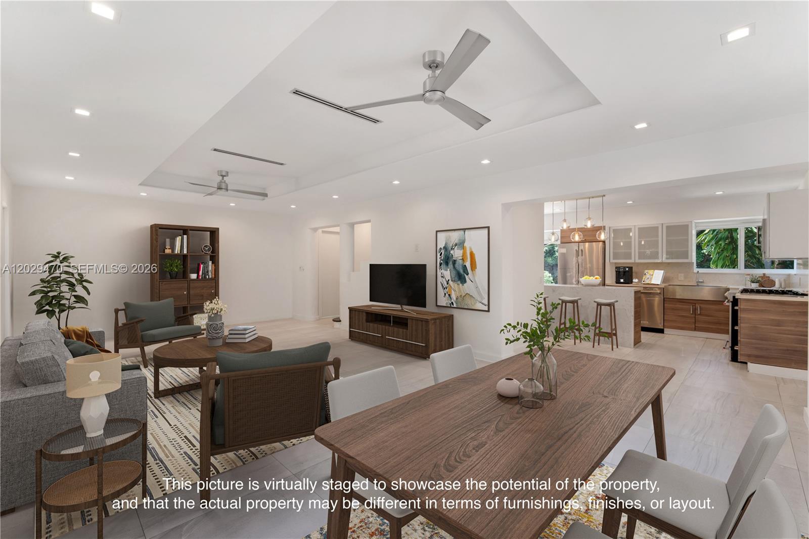 This virtually staged open-concept living and dining area features a modern kitchen and tray ceilings — 550 W 49th St, Miami Beach FL 33140, MIAMI BEACH, FL