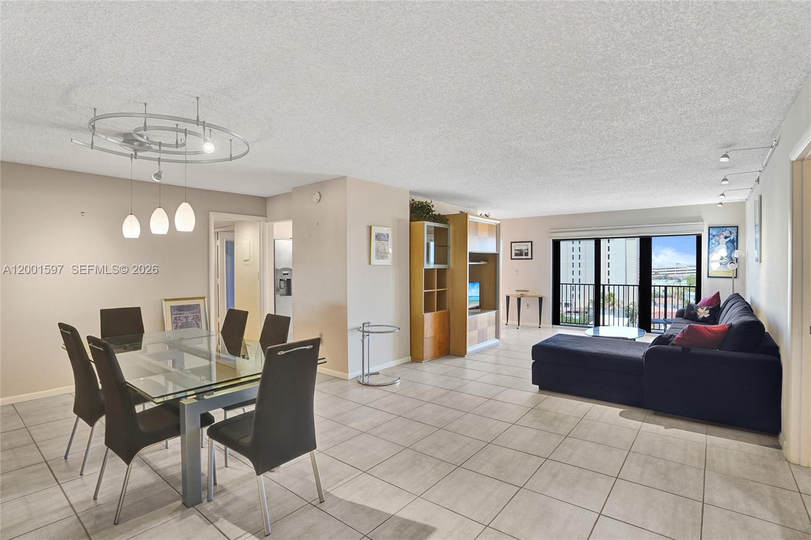 A dining area with a glass table and a living room with a dark sofa — 1201 S Ocean Dr # 604N, Hollywood FL 33019, HOLLYWOOD, FL