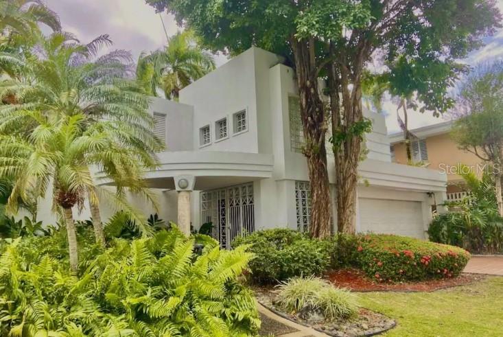 A two-story white house with a curved entryway, palm trees, and lush landscaping — 4 EBANO STREET UNIT 4, GUAYNABO, PR
