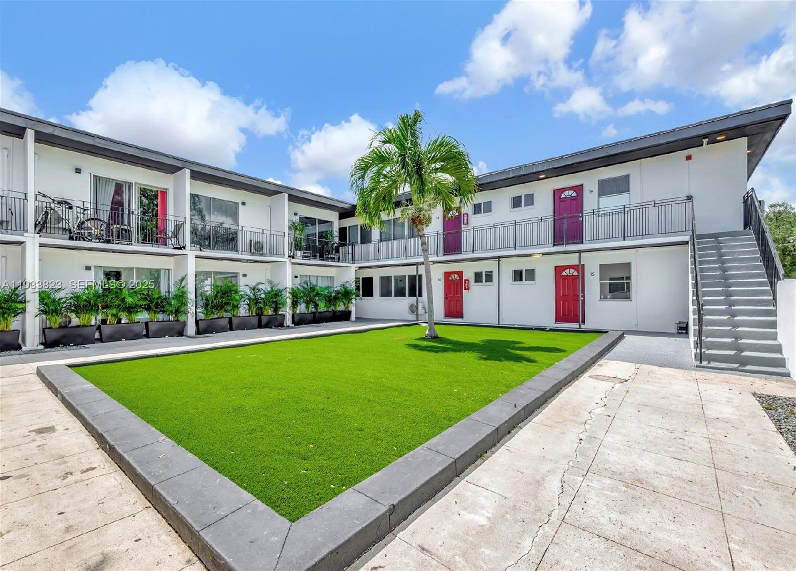 A two-story apartment building features a central courtyard with artificial turf and a palm tree — 14280 NE 6th Ave, North Miami FL 33161, NORTH MIAMI, FL